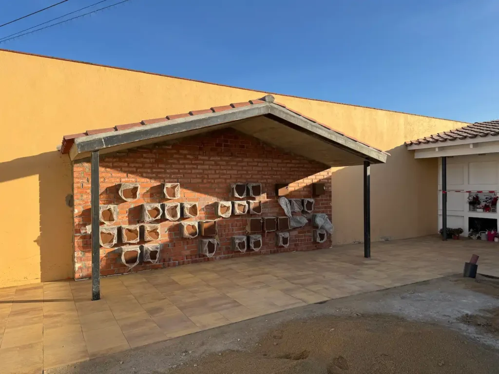Columbarios fijados sobre el muro de ladrillo del cementerio de Vilamalla, antes del revestimiento de piedra