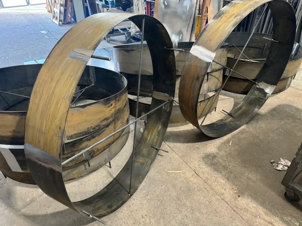 Aros de acero corten para alcorques de árbol en proceso de oxidación, en el taller