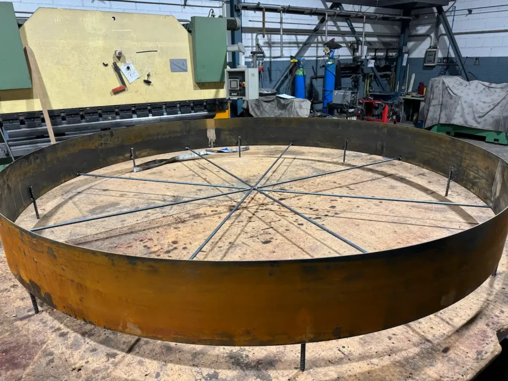 Alcorque de árbol en acero corten con su estructura interior de varillas, en proceso de oxidación en el taller