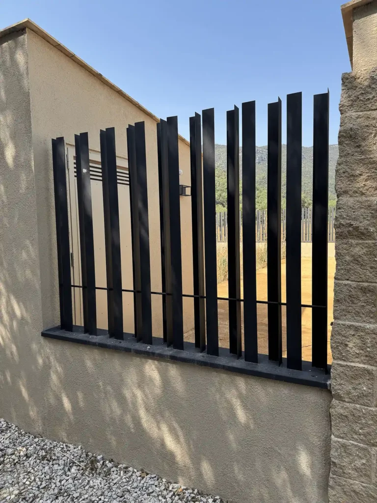 Detalle de la valla de angulares de acero sobre el muro perimetral del cementerio