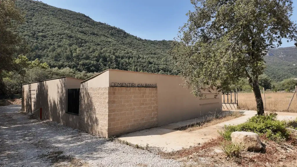 Vista general del cerramiento del cementerio de Albanyà, con el rótulo sobre el muro