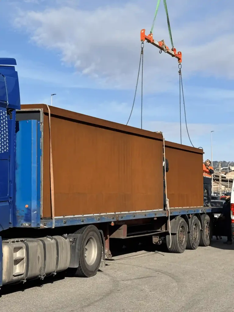 Dos módulos de columbarios de acero corten cargados sobre camión plataforma para su traslado a obra