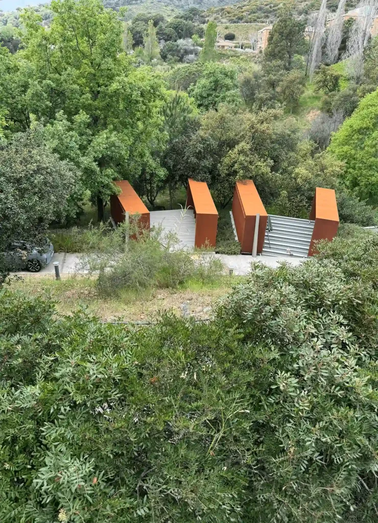 Vista elevada del columbario del Tanatori de Badalona entre la vegetación de la Serralada de Marina