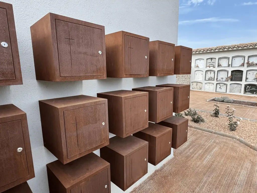 Detalle en perspectiva de los columbarios de acero corten con cruz calada, en el cementerio de Torre d'Oristà