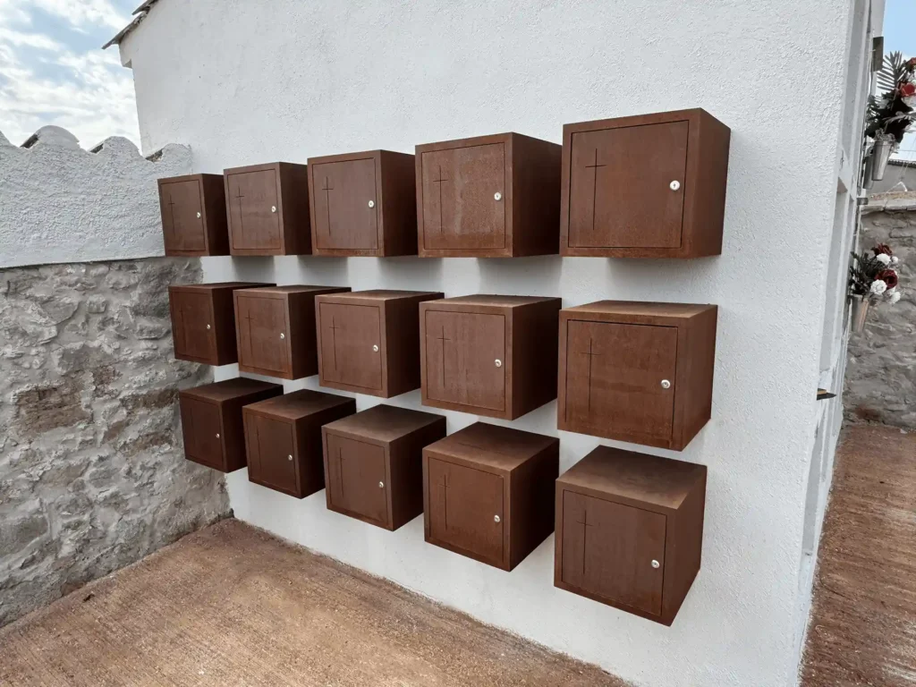 Perspectiva del muro con los columbarios individuales de acero corten instalados en el cementerio de Torre d'Oristà