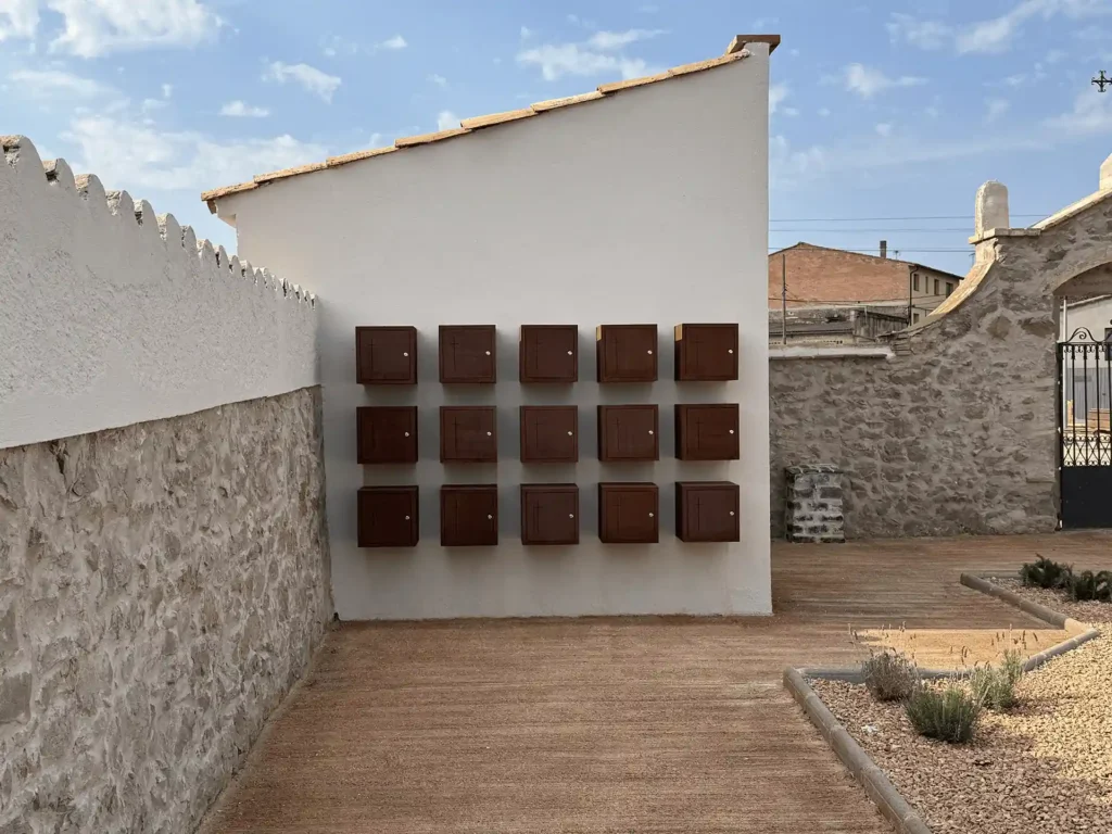 Vista general frontal del conjunto de quince columbarios de acero corten en el cementerio de Torre d'Oristà