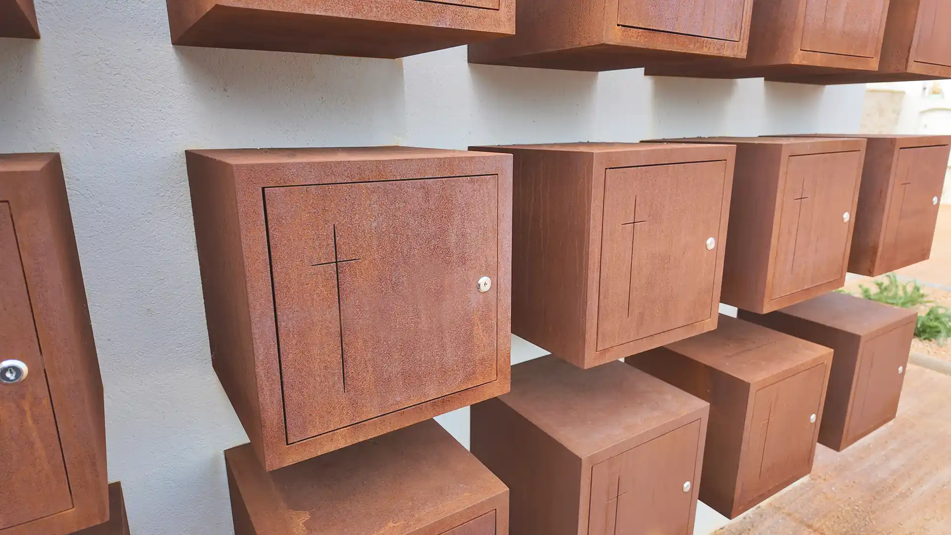 Columbarios de Acero Corten fijados en superficie de pared en cementerio municiopal de Oristà
